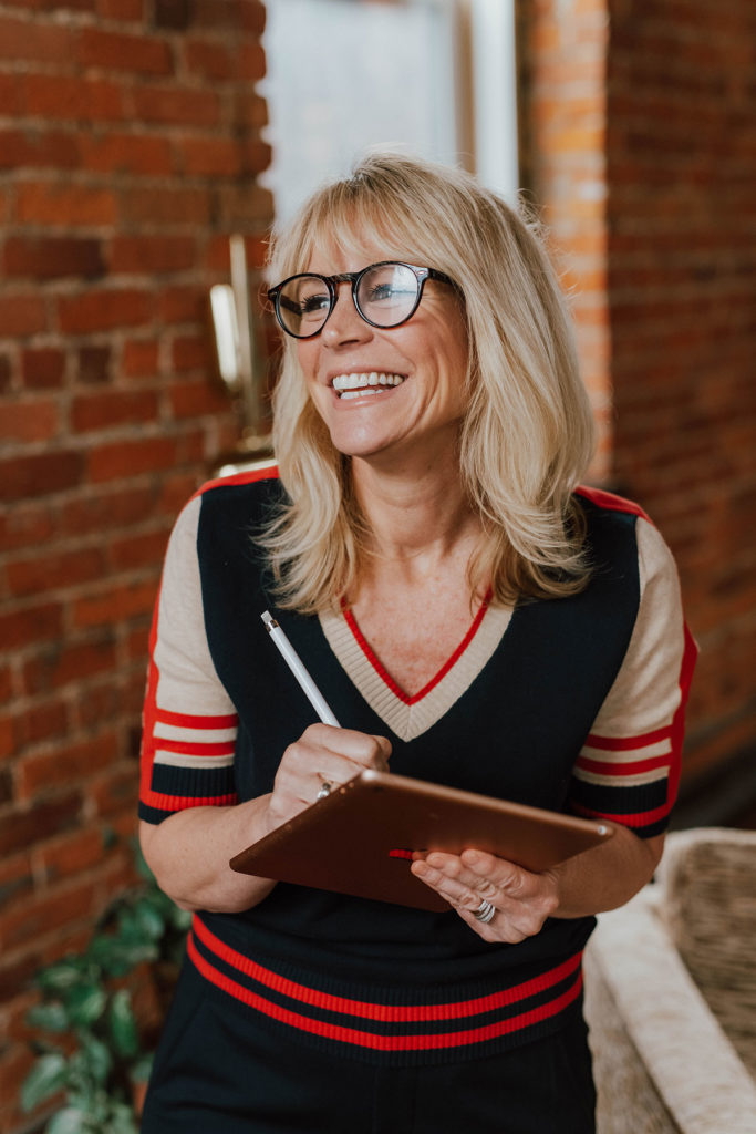 women entrepreneur in short sleeve blue sweater wearing glasses